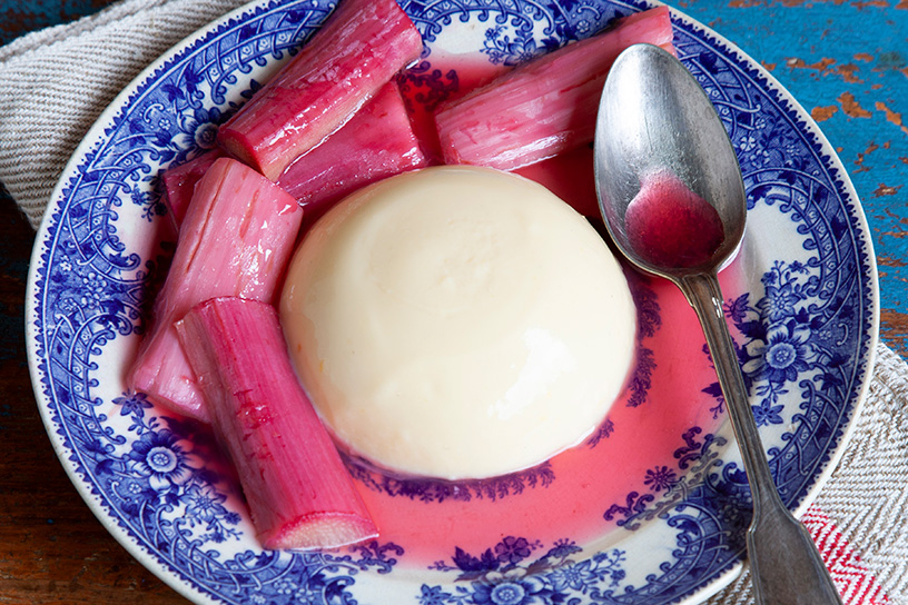 Custardpuddinkjes met rabarber op een bord.